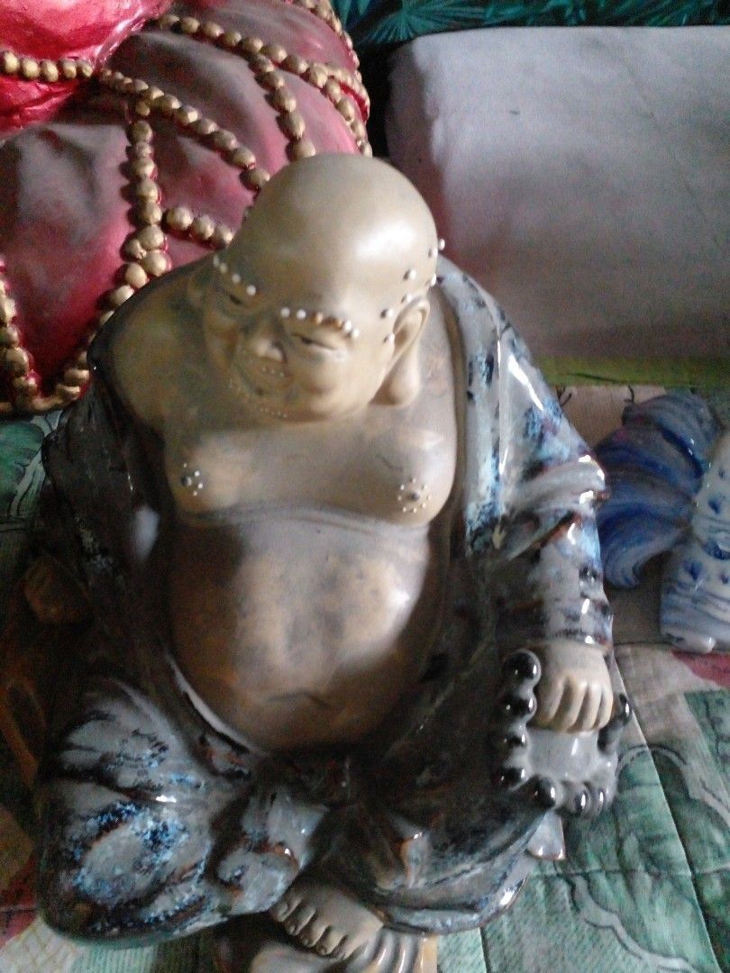 Ceramic Laughing Buddha Figurine with Blue Glaze (Category: Figurines & Statues) located in Quezon City. Submitted by madelrivera (Listing ID 1467997618, Image 1). Description: - Material: Solid ceramic with a sleek dark blue and grey glaze - Design: Laughing Buddha holding prayer beads with detailed facial features and decorative dots - Stability: Sits completely flat on any surface - Placement: Ideal for home altars, bookshelves, or office disp
