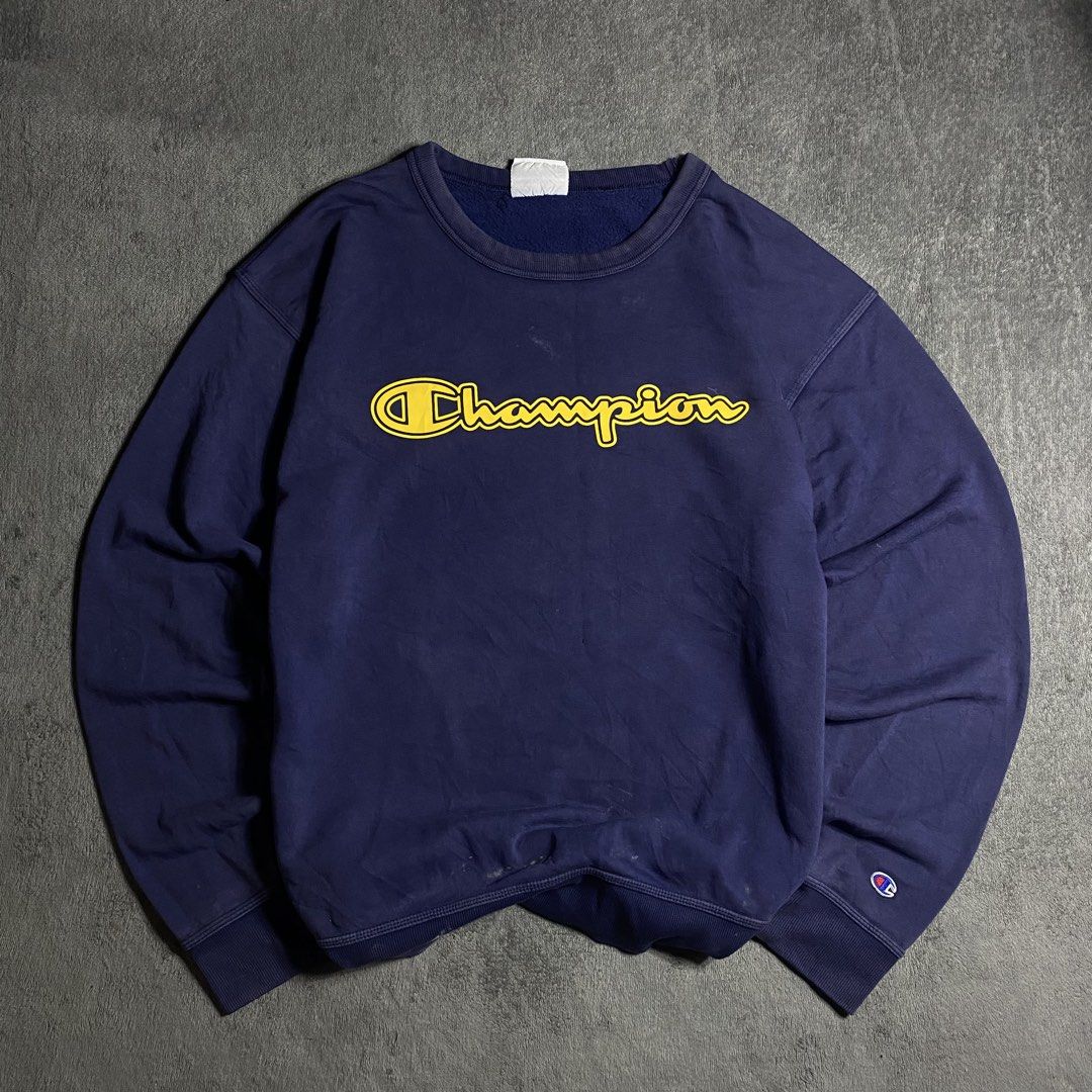 Champion Navy Blue Yellow Script Logo Crewneck Sweatshirt (Category: Coats, Jackets and Outerwear) located in Manila. Submitted by thrifturfit_star (Listing ID 1467845747, Image 1). Description: - Brand: Champion - Color: Navy blue with yellow script logo - Material: Soft fleece interior for maximum comfort - Fit: Classic boxy fit, great for everyday wear - Details: Ribbed collar, cuffs, and hem, plus the signature C logo patch on the left wrist 