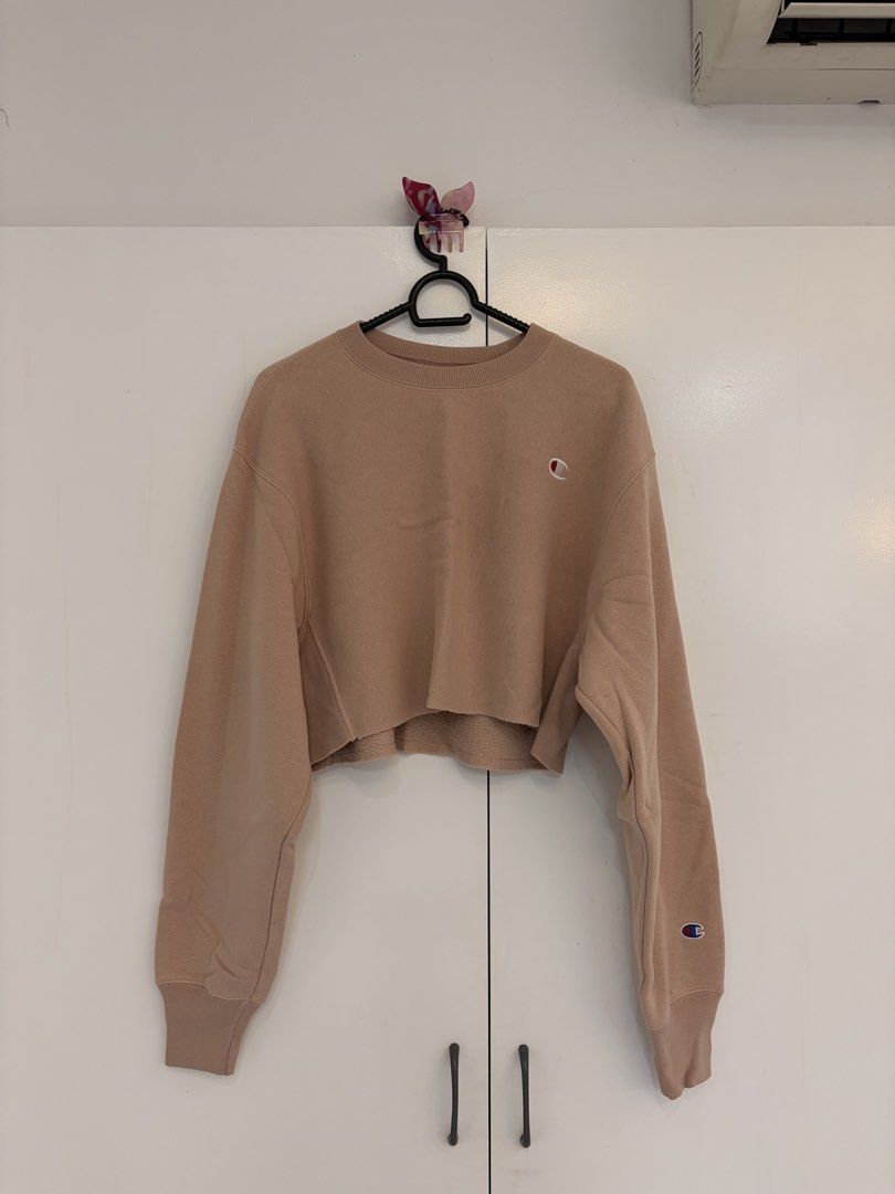Champion Nude Pink Crop Sweatshirt (Category: Coats, Jackets and Outerwear) located in Quezon City. Submitted by prelovedbynxkole (Listing ID 1467884873, Image 1). Description: - Brand: Champion Reverse Weave - Style: Cropped sweatshirt with raw hem cut and classic crewneck - Color: Nude pink - Size: X-Small (XS) - Material: Thick, heavyweight fleece interior for extra warmth - Details: Iconic embroidered Champion chest patch and 'C' logo on left