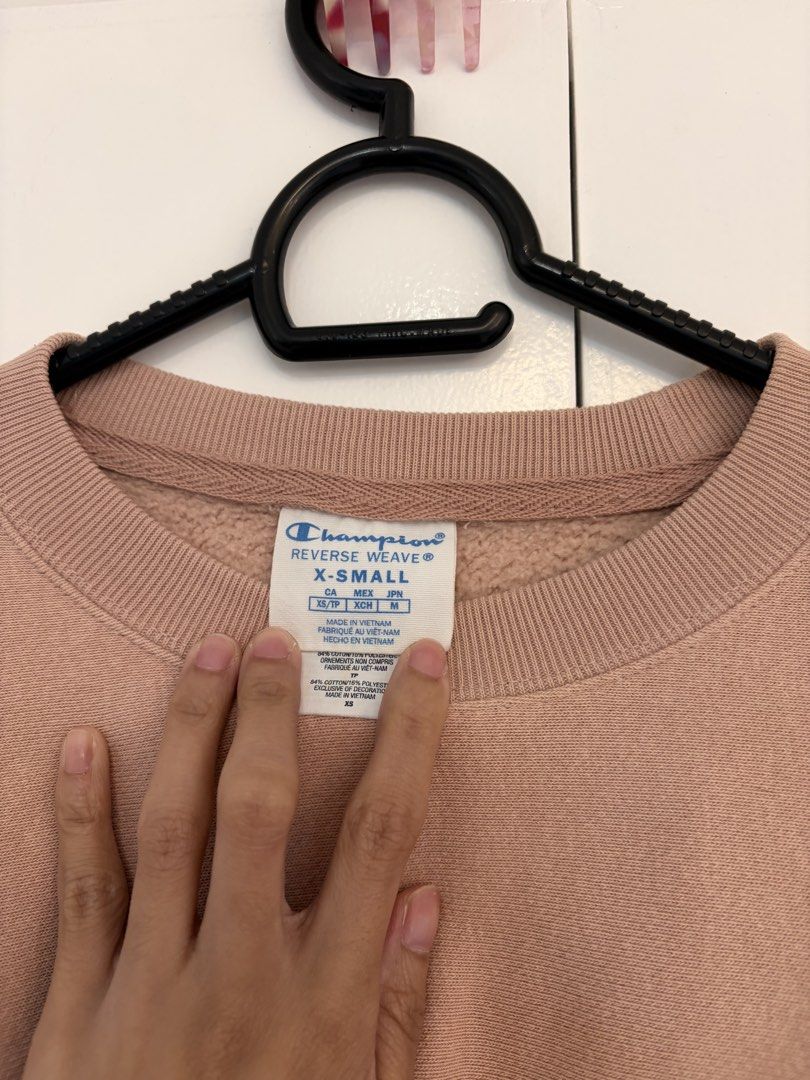 Champion Nude Pink Crop Sweatshirt (Category: Coats, Jackets and Outerwear) located in Quezon City. Submitted by prelovedbynxkole (Listing ID 1467884873, Image 2). Description: - Brand: Champion Reverse Weave - Style: Cropped sweatshirt with raw hem cut and classic crewneck - Color: Nude pink - Size: X-Small (XS) - Material: Thick, heavyweight fleece interior for extra warmth - Details: Iconic embroidered Champion chest patch and 'C' logo on left