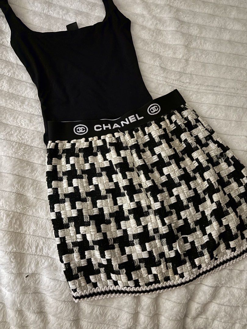 Chanel Black White Houndstooth Tweed Mini Skirt (Category: Skirts) located in Quezon City. Submitted by hadescloset (Listing ID 1468029524, Image 1). Description: - Style: Black and white houndstooth tweed mini skirt - Waistband: Elastic with bold white Chanel lettering and logo branding - Fit: Structured flared cut - Details: Scalloped trim finish along the bottom hem - Styling: Pairs easily with basic black tops and tees.