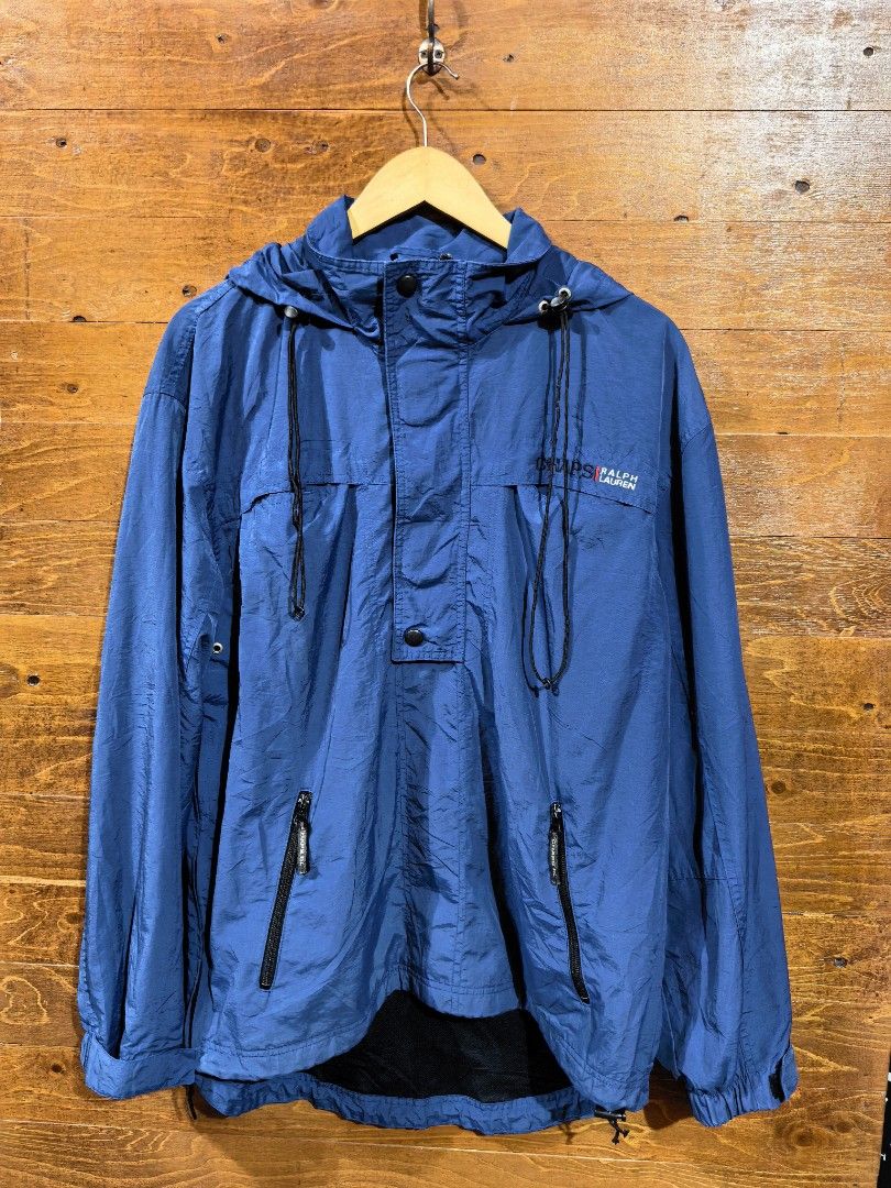 Chaps Ralph Lauren Blue Anorak Windbreaker Jacket (Category: Coats, Jackets and Outerwear) located in Paranaque City. Submitted by caboodlespremium (Listing ID 1468003942, Image 1). Description: Dimes: L-27in W- 17in Chaps Ralph Lauren anorak windbreaker jacket in blue. Half zip front with snap button placket and adjustable hood drawstrings. Embroidered logo on the chest. Dual zippered front pockets. Mesh lining inside. Elastic cuffs and adjustab