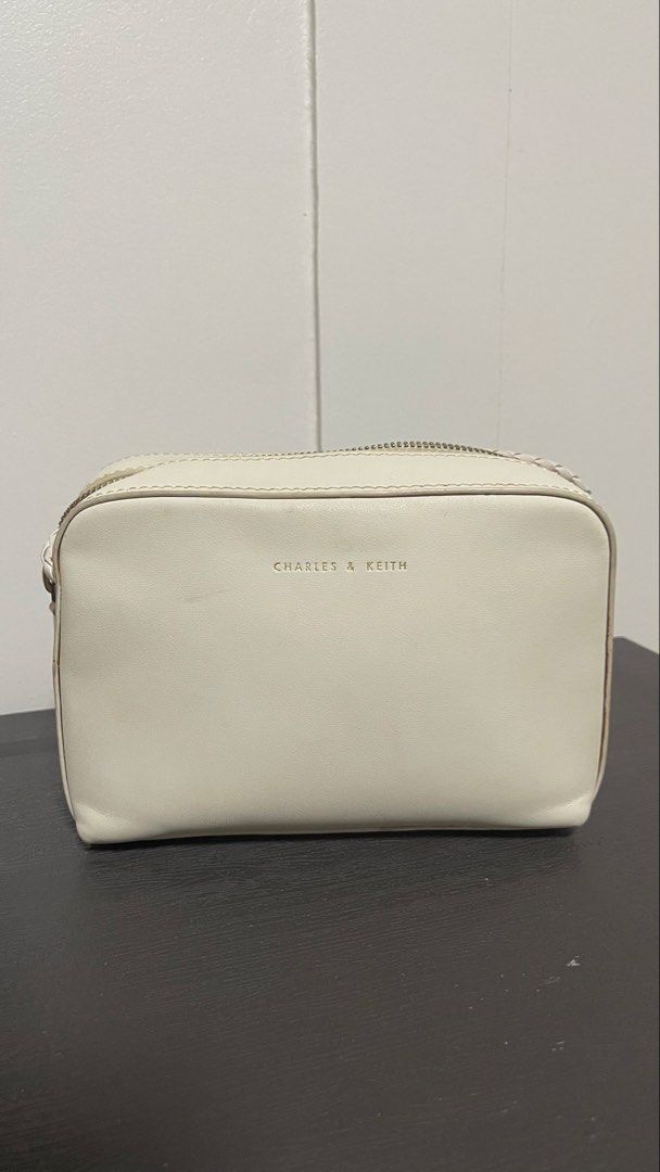 Charles & Keith White Crossbody Bag with Braided Strap (Category: Cross-body Bags) located in Magalang. Submitted by josephinenl (Listing ID 1467897794, Image 1). Description: Authentic. Good condition. Brand: Charles & Keith - Style: Camera bag / purse - Color: Versatile off-white neutral - Details: Gold foil brand lettering on front - Closure: Secure double zipper across the top - Strap: Long, stylish braided strap - Shape: Clean and structured