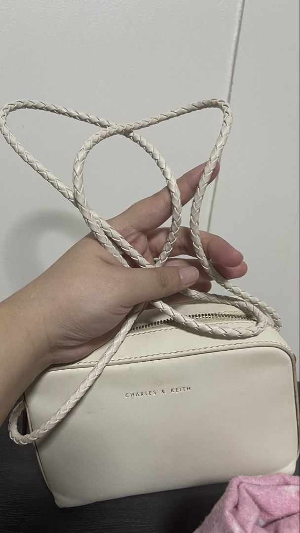 Charles & Keith White Crossbody Bag with Braided Strap (Category: Cross-body Bags) located in Magalang. Submitted by josephinenl (Listing ID 1467897794, Image 3). Description: Authentic. Good condition. Brand: Charles & Keith - Style: Camera bag / purse - Color: Versatile off-white neutral - Details: Gold foil brand lettering on front - Closure: Secure double zipper across the top - Strap: Long, stylish braided strap - Shape: Clean and structured
