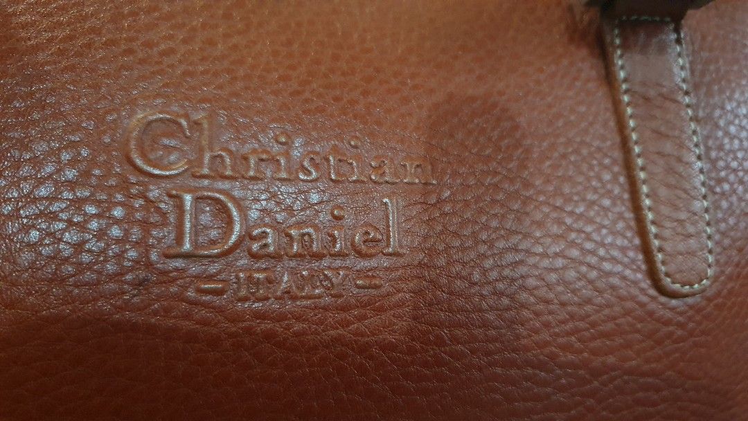 Christian Daniel Red Leather Handbag (Category: Luxury Bags & Wallets) located in Las Pinas. Submitted by imhislily (Listing ID 1467928588, Image 2). Description: - Brand: Christian Daniel - Color: Vibrant rust with contrast white stitching - Material: Premium pebble grain leather texture - Design: Structured body with embossed front logo - Handles: Double top handles with metallic hardware - Closure: Secure zip top closure.