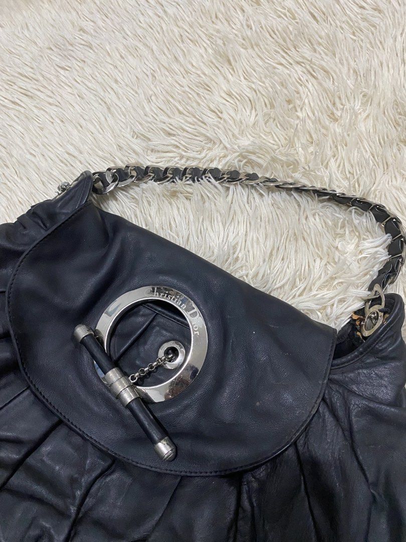 Christian Dior jazzBlack Leather Handbag (Category: Luxury Bags & Wallets) located in Antipolo. Submitted by switchneighborhood (Listing ID 1467870569, Image 2). Description: - Brand: Christian Dior - Material: Black leather with soft, slouchy silhouette -NEEDS CLEANING AND SOME RESTORATIONS AS SEEN ON PIC - Design: Elegant gathered ruching detail - Hardware: Silver-tone with circular front closure, chain, and toggle bar accent - Strap: Interwove