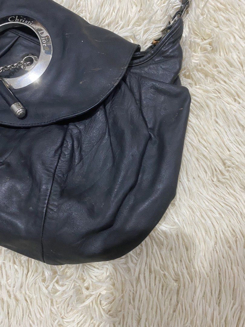 Christian Dior jazzBlack Leather Handbag (Category: Luxury Bags & Wallets) located in Antipolo. Submitted by switchneighborhood (Listing ID 1467870569, Image 3). Description: - Brand: Christian Dior - Material: Black leather with soft, slouchy silhouette -NEEDS CLEANING AND SOME RESTORATIONS AS SEEN ON PIC - Design: Elegant gathered ruching detail - Hardware: Silver-tone with circular front closure, chain, and toggle bar accent - Strap: Interwove