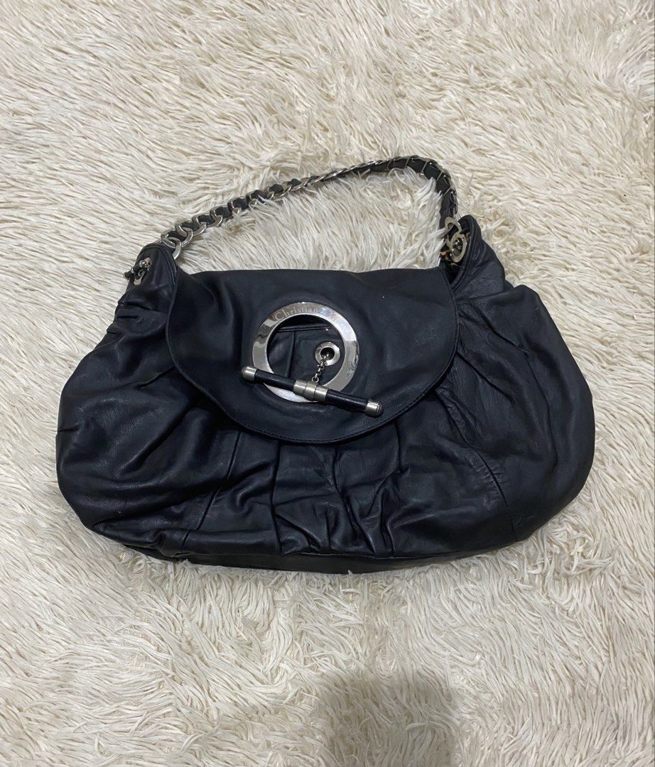 Christian Dior jazzBlack Leather Handbag (Category: Luxury Bags & Wallets) located in Antipolo. Submitted by switchneighborhood (Listing ID 1467870569, Image 1). Description: - Brand: Christian Dior - Material: Black leather with soft, slouchy silhouette -NEEDS CLEANING AND SOME RESTORATIONS AS SEEN ON PIC - Design: Elegant gathered ruching detail - Hardware: Silver-tone with circular front closure, chain, and toggle bar accent - Strap: Interwove