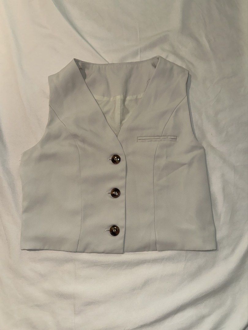 classy cream cropped vest top (Category: Sleeveless) located in Quezon City. Submitted by kalmai (Listing ID 1467917267, Image 1). Description: - Color: Cream - Style: Cropped tailored suit vest - Details: V-neckline, 3 tortoise shell buttons, small faux chest pocket - Fit: Structured and flattering - Versatility: Great for layering over tees or wearing on its own - Condition: Brand new / Excellent .
