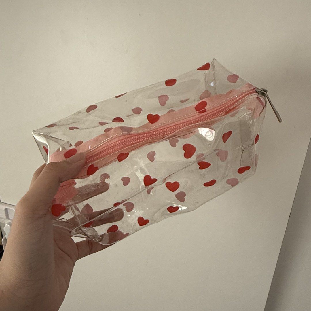 Clear Heart Print Makeup Pouch Cosmetic Bag (Category: Purses & Pouches) located in Marikina City. Submitted by lovegoeson (Listing ID 1467989799, Image 3). Description: - Design: Clear pouch with cute pink and red heart pattern - Closure: Secure pink zipper along the top - Shape: Roomy rectangular design for maximum storage - Versatile: Great for travel, makeup, stationery, or daily essentials - Material: Lightweight plastic that is easy to wipe