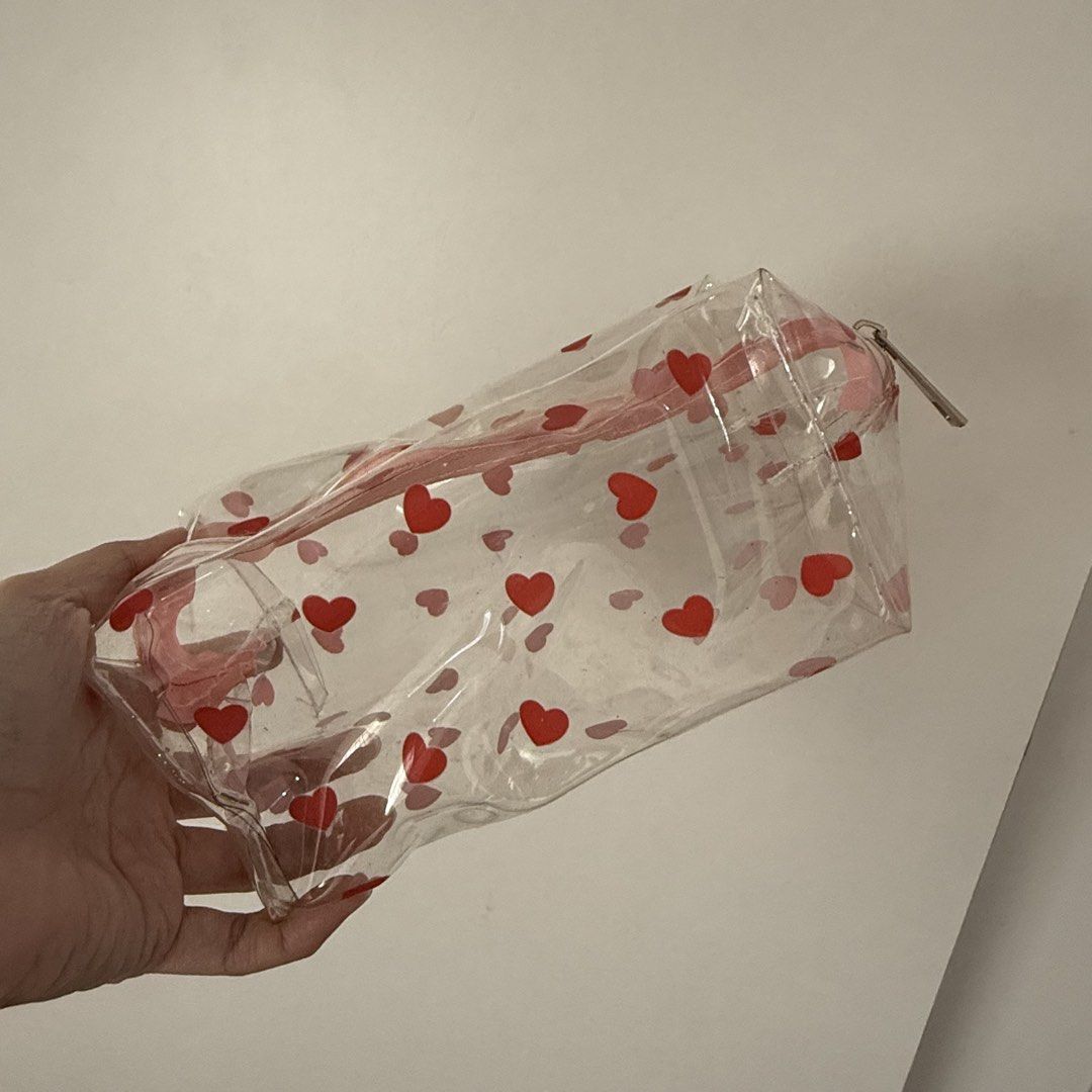 Clear Heart Print Makeup Pouch Cosmetic Bag (Category: Purses & Pouches) located in Marikina City. Submitted by lovegoeson (Listing ID 1467989799, Image 2). Description: - Design: Clear pouch with cute pink and red heart pattern - Closure: Secure pink zipper along the top - Shape: Roomy rectangular design for maximum storage - Versatile: Great for travel, makeup, stationery, or daily essentials - Material: Lightweight plastic that is easy to wipe