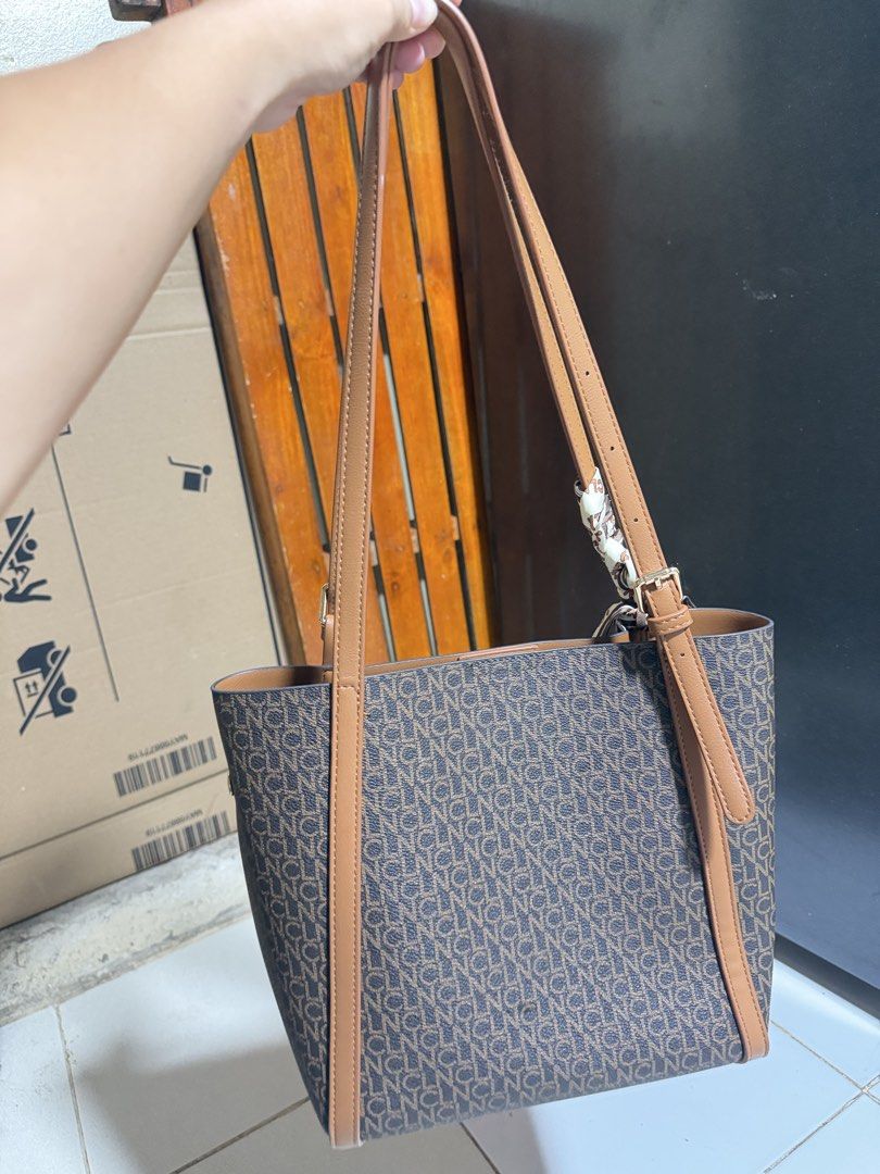 CLN Monogram Tote Bag with Scarf Accent (Category: Tote Bags) located in Las Pinas. Submitted by sugaaarr (Listing ID 1467862357, Image 2). Description: - Brand: CLN - Color: Brown and tan monogram - Design: Durable structured shoulder bag - Straps: Dual straps with adjustable buckles - Pockets: Front slip pocket with button accent - Hardware: Elegant gold-tone details - Inclusion: Matching patterned twill scarf tied on the handle.