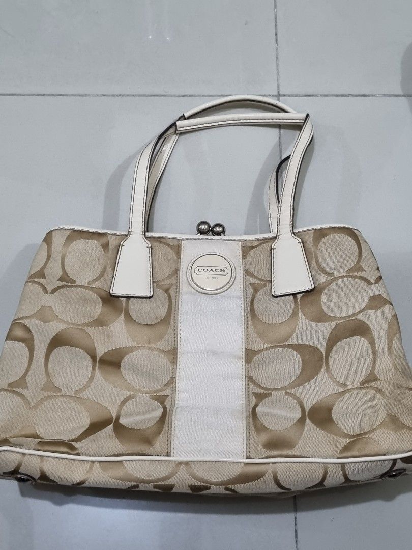 Coach Canvas Kisslock (Category: Luxury Bags & Wallets) located in Quezon City. Submitted by gabdclutz (Listing ID 1468005027, Image 1). Description: - Brand: Coach - Style: Signature C pattern everyday tote / handbag - Color: Beige and white canvas - Closure: Kiss-lock hardware at the top - Interior: Fabric lining with Coach creed patch (B1171-F17424) - Features: Sturdy base feet for protection - Condition: Double top handles have visible wear, 
