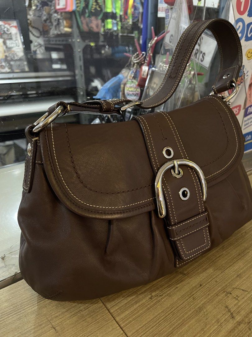 Coach Leather Shoulder Bag Brown & Black (Category: Luxury Bags & Wallets) located in Manila. Submitted by lycahatesyou (Listing ID 1467995851, Image 1). Description: - Authentic vintage-style Coach leather shoulder bag - Soft, slouchy body shape for comfortable everyday wear - Secure front buckle closure with stylish contrast stitching - Single strap design accented with sleek silver-tone hardware - Practical interior featuring a zip pocket and 