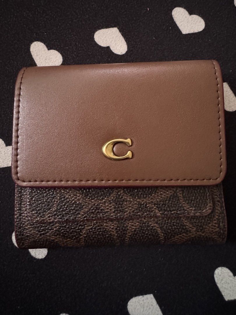 Coach Mila Small Flap Wallet (Category: Luxury Bags & Wallets) located in Quezon City. Submitted by minekoh21 (Listing ID 1467904178, Image 1). Description: - Brand: Coach - Style: Trifold wallet - Material: Leather - Color: Brown (standard Coach color) - Hardware: Gold-tone - Closure: Front snap with signature C logo - Exterior: Back zipper pocket for coins - Interior: Multiple card slots, cash compartment, and Coach New York embossed stamp Prod