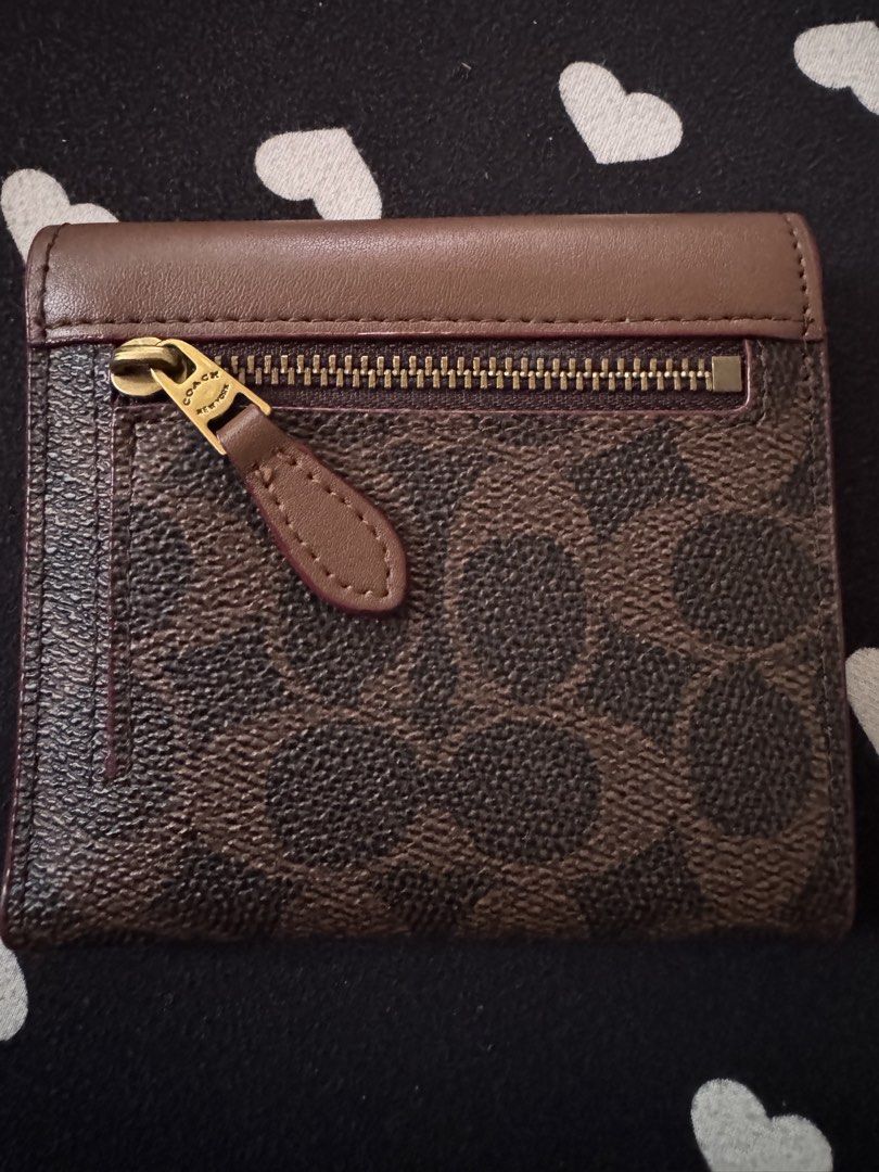 Coach Mila Small Flap Wallet (Category: Luxury Bags & Wallets) located in Quezon City. Submitted by minekoh21 (Listing ID 1467904178, Image 2). Description: - Brand: Coach - Style: Trifold wallet - Material: Leather - Color: Brown (standard Coach color) - Hardware: Gold-tone - Closure: Front snap with signature C logo - Exterior: Back zipper pocket for coins - Interior: Multiple card slots, cash compartment, and Coach New York embossed stamp Prod