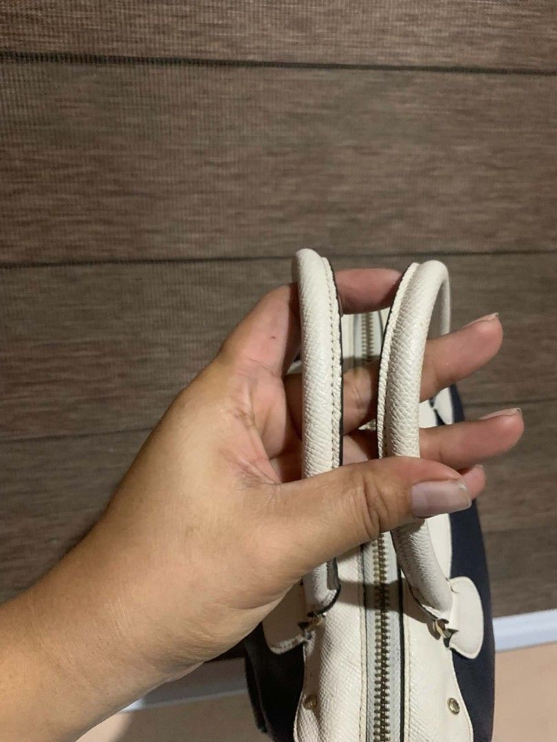 Coach Navy and White Satchel Bag (Category: Luxury Bags & Wallets) located in Aliaga. Submitted by akishaoshop2010. (Listing ID 1468055103, Image 2). Description: - Brand: Coach - Color: Dark navy and white - Material: Premium textured leather - Hardware: Gold-tone with Coach New York logo stamp - Closure: Zip-around - Handles: Dual top handles - Design: Structured shape with protective side panels - Condition: Excellent.
