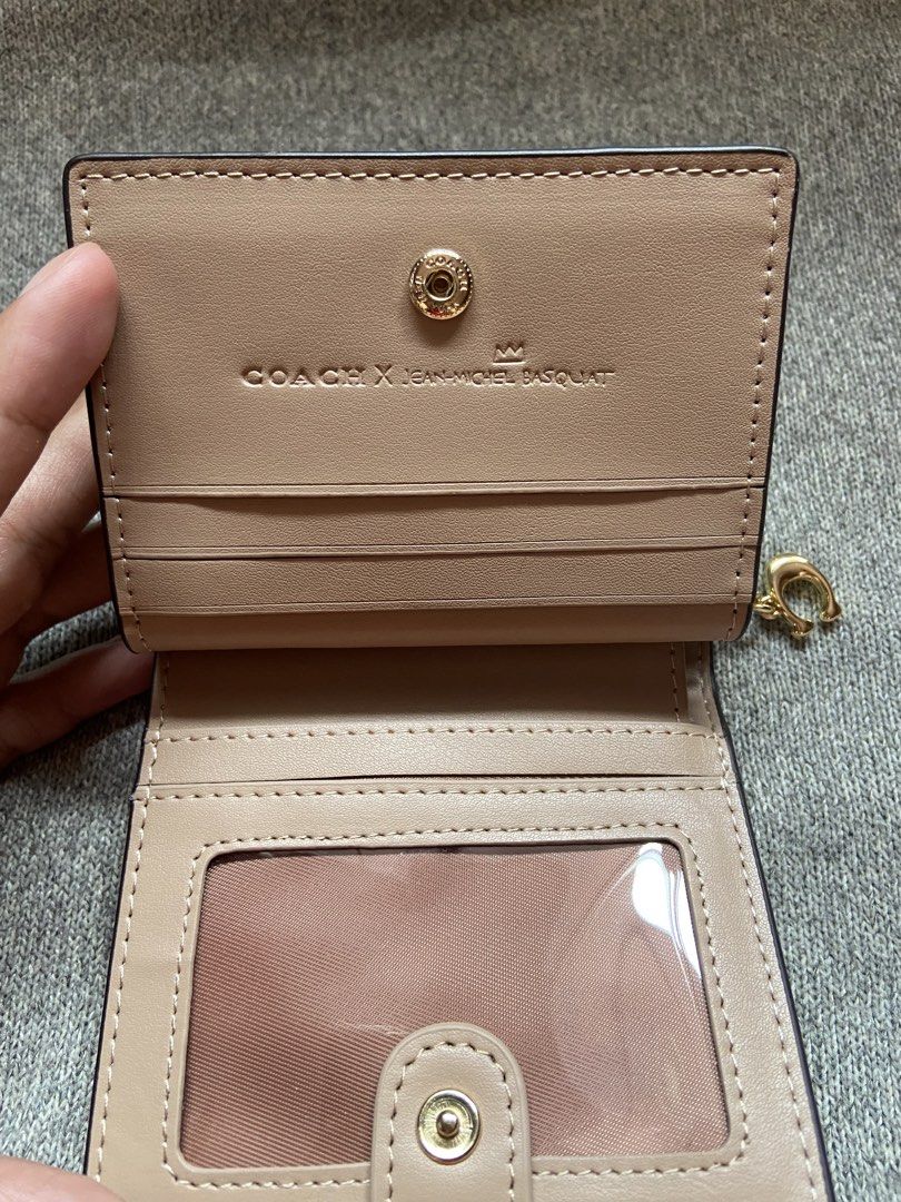 Coach x Basquiat Jean Michel Wallet (Category: Luxury Bags & Wallets) located in Makati City. Submitted by ellope (Listing ID 1460780327, Image 3). Description: Coach x Jean-Michel Basquiat bifold wallet in cream pebbled leather with iconic graphic print. Features card slots, ID window, and gold hardware. .