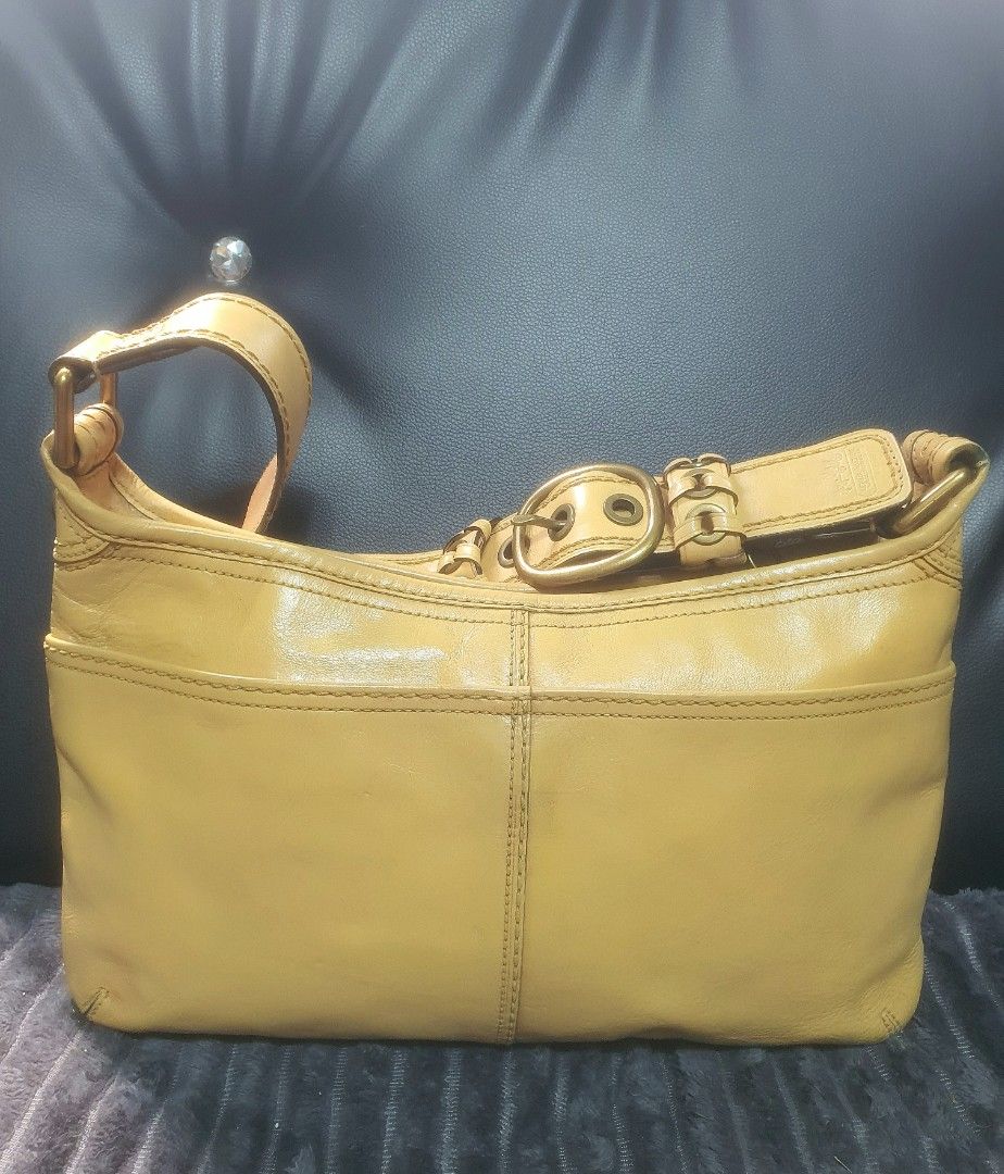 Coach Yellow Leather Shoulder Bag with Buckle Strap (Category: Luxury Bags & Wallets) located in Manila. Submitted by mozaitv1236506 (Listing ID 1467873507, Image 2). Description: - Authentic Coach leather shoulder bag in a gorgeous mustard yellow - Antique brass hardware and stylish contrast stitching detail - Secure top zipper closure with clean interior - Practical size for daily essentials - Minor signs of previous use on leather and hardware