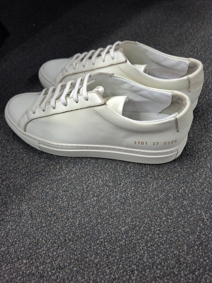 Common Projects Woman Achilles Low White Size 37 (Category: Sneakers) located in Quezon City. Submitted by shawnstussy (Listing ID 1467853708, Image 1). Description: - Brand: Common Projects - Color: White - Material: Smooth leather upper with tonal rubber cupsole - Origin: Made in Italy - Design: Classic minimalist style with iconic gold serial number on the heel - Details: Flat cotton laces and gold stamped branding on the insole - Condition: M