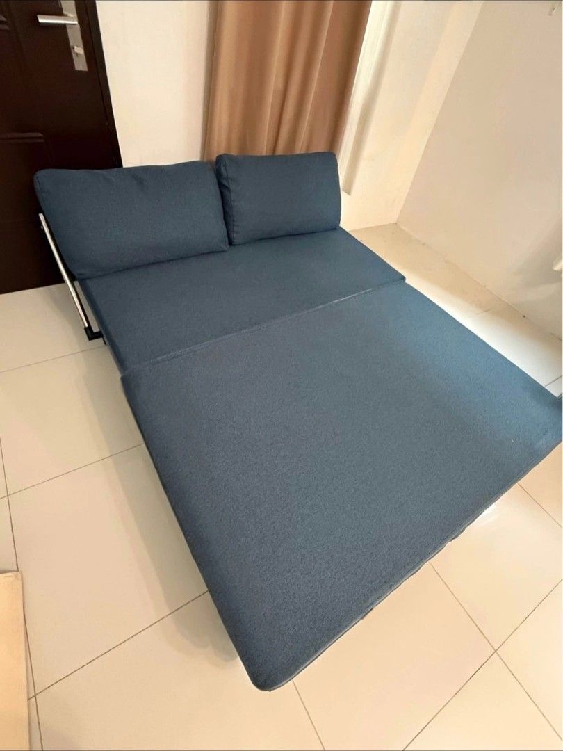 Convertible Sofa Bed (Category: Sofas) located in Taguig. Submitted by apzdeclutter (Listing ID 1468029076, Image 3). Description: - Color: Clean blue upholstery with a sleek black metal frame - Function: Easily converts from a standard two-seater couch to a flat sleeping surface - Inclusions: Comes with two matching throw pillows - Ideal for: Living rooms, condo units, or guest rooms as a space-saving solution - Condition: Well-maintained and st