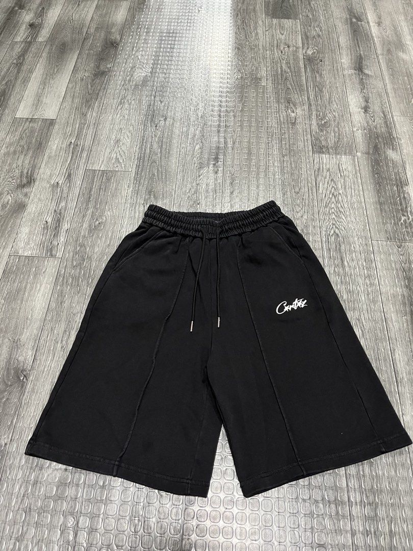 Corteiz Black Sweatshorts HMP (Category: Shorts) located in Manila. Submitted by carloradan59718 (Listing ID 1467872493, Image 1). Description: Black Corteiz sweatshorts with adjustable drawstring waist. White script logo printed near the left front pocket. Back right pocket features a graphic patch with red stars and HMP text. Comfortable thick cotton fleece material. Clean condition overall, minimal wear..