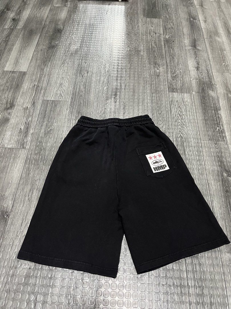 Corteiz Black Sweatshorts HMP (Category: Shorts) located in Manila. Submitted by carloradan59718 (Listing ID 1467872493, Image 2). Description: Black Corteiz sweatshorts with adjustable drawstring waist. White script logo printed near the left front pocket. Back right pocket features a graphic patch with red stars and HMP text. Comfortable thick cotton fleece material. Clean condition overall, minimal wear..