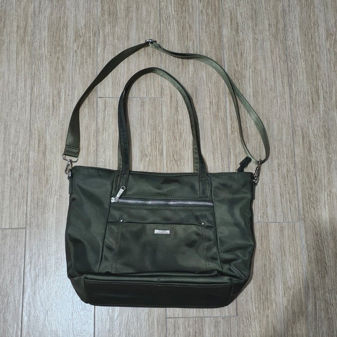 Cose Olive Green Nylon Shoulder Strap (Category: Tote Bags) located in Quezon City. Submitted by reply_1982 (Listing ID 1467841752, Image 1). Description: Olive green nylon tote bag with dual top handles and adjustable long shoulder strap. Silver hardware and Cose metal brand tag on the front zip pocket. Back side features an additional zipper pocket. Inside is lined with light gray fabric, including a zip pocket and slip pockets for organization