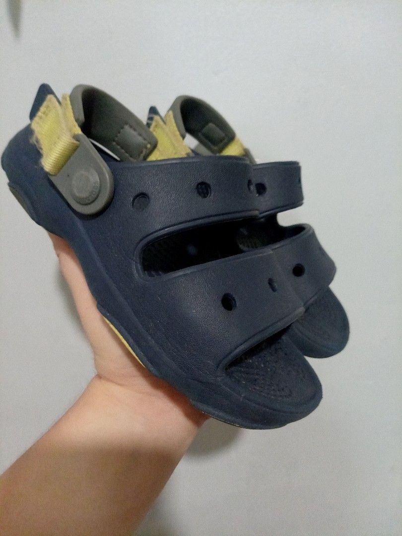 Crocs Kids Sandals Blue Size C12 (Category: Babies & Kids Fashion) located in Valenzuela. Submitted by yshymng (Listing ID 1467863863, Image 1). Description: Navy blue kids sandals from Crocs. Size C12 stamped on the sole. Adjustable strap at the back with velcro closure in yellowish green. Two strap design with side ventilation holes. Grippy rubber sole with contrast rubber inserts. Normal signs of wear visible on the bottom treads and fabric st