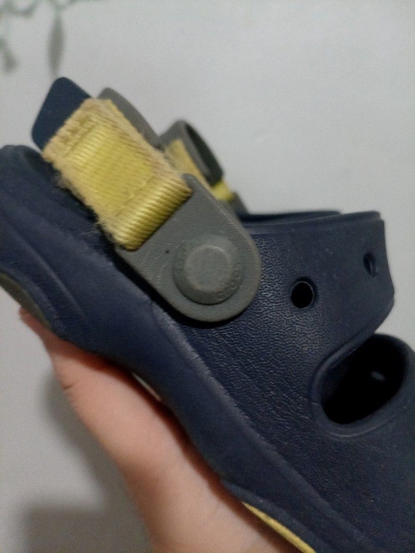 Crocs Kids Sandals Blue Size C12 (Category: Babies & Kids Fashion) located in Valenzuela. Submitted by yshymng (Listing ID 1467863863, Image 3). Description: Navy blue kids sandals from Crocs. Size C12 stamped on the sole. Adjustable strap at the back with velcro closure in yellowish green. Two strap design with side ventilation holes. Grippy rubber sole with contrast rubber inserts. Normal signs of wear visible on the bottom treads and fabric st