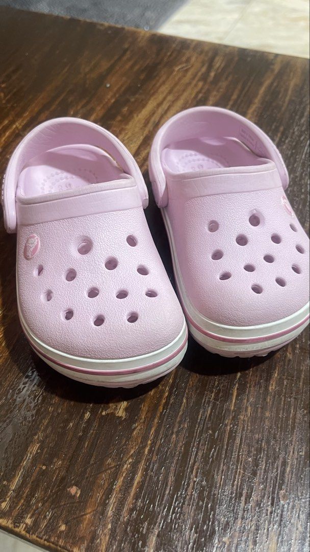 Crocs Pink Clogs Size 7 (Category: Slippers and slides) located in Paranaque City. Submitted by bulditah (Listing ID 1467864906, Image 1). Description: - Color: Pink with white stripe detail along the midsole - Size: C7 (visible on the bottom) - Style: Slip-on with pivoting heel straps - Features: Ventilation holes on top for breathability - Condition: Clean soles with good tread remaining - Great for everyday casual use and comfort.