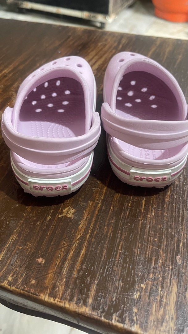 Crocs Pink Clogs Size 7 (Category: Slippers and slides) located in Paranaque City. Submitted by bulditah (Listing ID 1467864906, Image 3). Description: - Color: Pink with white stripe detail along the midsole - Size: C7 (visible on the bottom) - Style: Slip-on with pivoting heel straps - Features: Ventilation holes on top for breathability - Condition: Clean soles with good tread remaining - Great for everyday casual use and comfort.