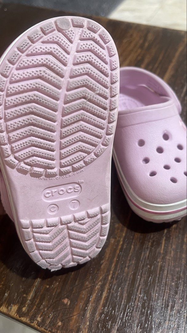 Crocs Pink Clogs Size 7 (Category: Slippers and slides) located in Paranaque City. Submitted by bulditah (Listing ID 1467864906, Image 2). Description: - Color: Pink with white stripe detail along the midsole - Size: C7 (visible on the bottom) - Style: Slip-on with pivoting heel straps - Features: Ventilation holes on top for breathability - Condition: Clean soles with good tread remaining - Great for everyday casual use and comfort.