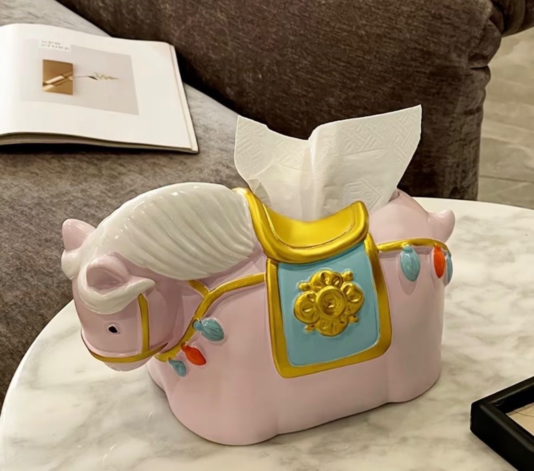 Cute Pink Horse Tissue Box Holder Table Decor (Category: Designer & Blind Box Toys) located in Subic. Submitted by anything_lovely_under_the_sun (Listing ID 1467917283, Image 1). Description: - Adorable pink horse design with stylish gold and blue saddle accents - Fits standard facial tissues easily - Dimensions: 23cm (L) x 14cm (W) x 13.5cm (H) - Adds a fun and playful touch to living room or bedroom tables - Great conversation piece and home de