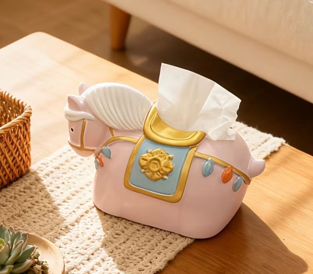 Cute Pink Horse Tissue Box Holder Table Decor (Category: Designer & Blind Box Toys) located in Subic. Submitted by anything_lovely_under_the_sun (Listing ID 1467917283, Image 3). Description: - Adorable pink horse design with stylish gold and blue saddle accents - Fits standard facial tissues easily - Dimensions: 23cm (L) x 14cm (W) x 13.5cm (H) - Adds a fun and playful touch to living room or bedroom tables - Great conversation piece and home de