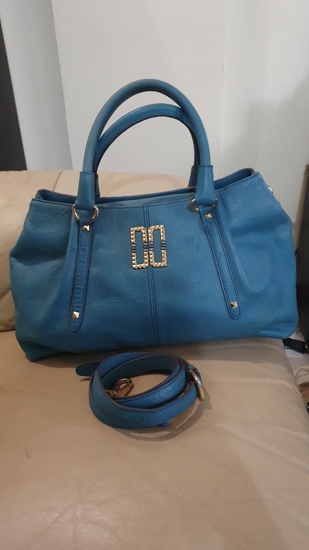 DAKS Blue Leather Handbag With Detachable Strap (Category: Shoulder Bags) located in Las Pinas. Submitted by imhislily (Listing ID 1467931523, Image 1). Description: - Color: Blue - Material: Premium leather with gold-tone hardware - Handles: Structured dual handles plus a matching detachable shoulder strap - Design: Distinctive metallic double-rectangle lock with stud accents and soft top pleating - Compartment: Roomy main compartment for all yo