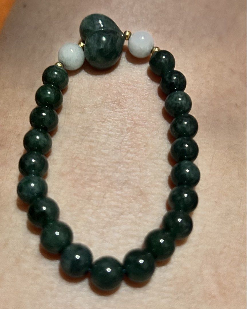 Dark Green and White Jadeite Beaded Bracelet (Category: Bracelets) located in Marikina City. Submitted by tresariascats (Listing ID 1467915705, Image 1). Description: - Material: Smooth polished green and dark green jade beads - Accents: Two light white-ish jade beads with tiny gold spacers - Pendant: Beautiful larger heart-shaped dark green jade at the top - Fit: Comfortable elastic cord for easy wearing - Condition: Brand new and ready to wear 