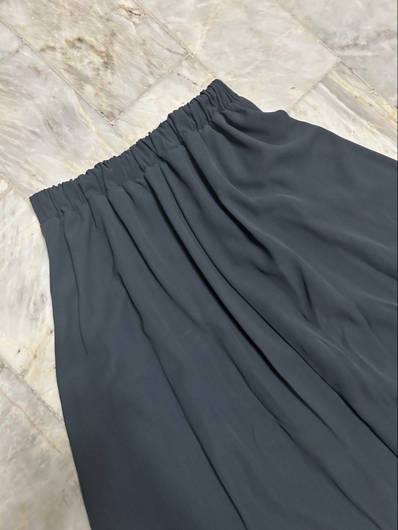Dark Grey Midi Skirt (Category: Skirts) located in Paranaque City. Submitted by jeanfrommanila (Listing ID 1467961940, Image 2). Description: - Color: Dark grey - Length: Midi - Material: Lightweight, flowy fabric - Features: Front pleats, comfortable elastic back waistband - Style: Versatile for casual days or office wear - Condition: Clean, ready to wear waist: 24-30 inches length: 29.5 inches.