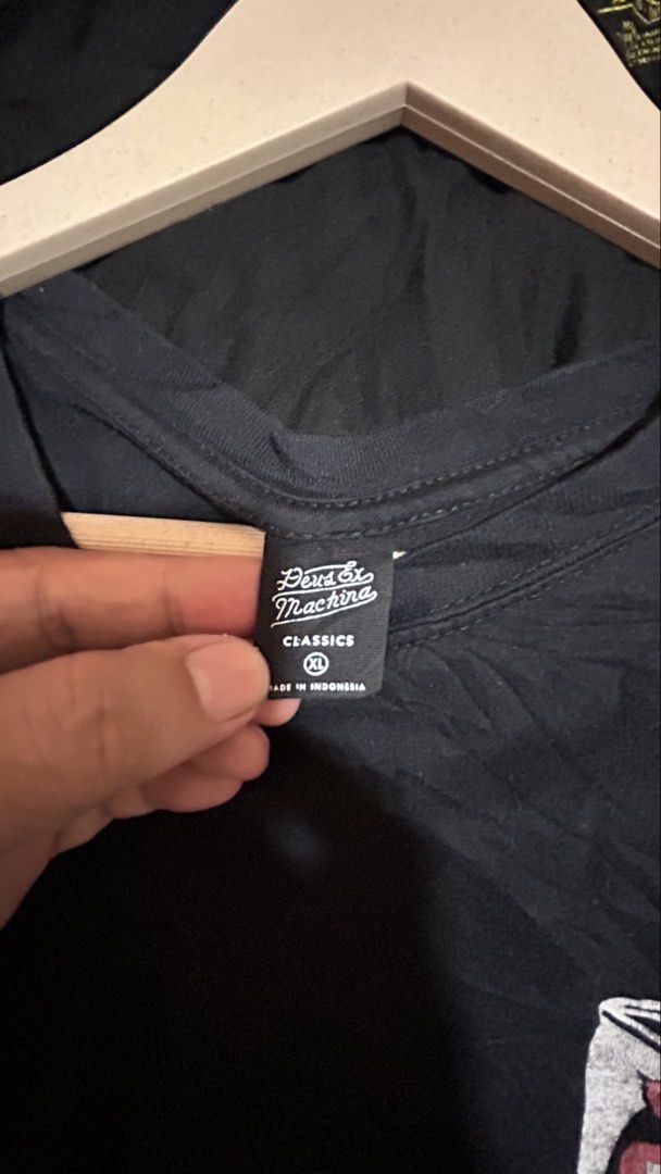Deus Ex Machina Bali Classics (Dimes: 23W 28L) (Category: Tshirts & Polo Shirts ) located in General Santos City (Dadiangas). Submitted by moana_thrifts (Listing ID 1467926441, Image 3). Description: - Brand: Deus Ex Machina - Color: Black - Size: XL (Regular fit, standard crew neck) - Material: 100% Organic Cotton (Made in Indonesia) - Design: Small front chest graphic, large Bali Canggu print on the back - Authenticity: Includes interior CertiE