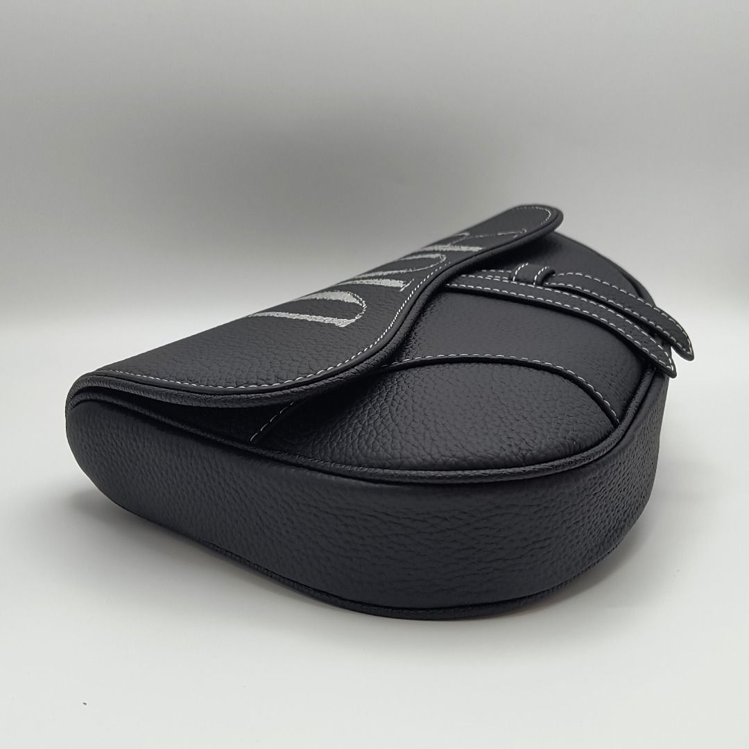 Dior x Alex Foxton Saddle Bag Black (Category: Luxury Bags & Wallets) located in Lapu Lapu. Submitted by theluxxaffair (Listing ID 1468050695, Image 3). Description: Dior Men x Alex Foxton Saddle bag crafted in black grained calfskin leather with contrasting white stitching and oversized DIOR lettering across the flap. Features the signature curved Saddle silhouette, adjustable Christian Dior nylon shoulder strap with industrial-style CD buckle, 