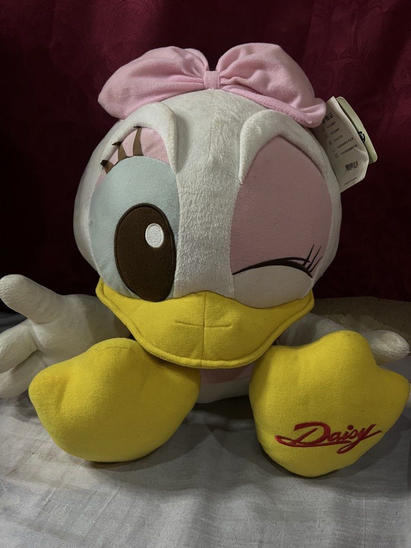 Disney Daisy Duck Plush Toy Doll (Category: Plushies & Soft Toys) located in Bulacan. Submitted by haven_plushie_dolls.888 (Listing ID 1467958508, Image 1). Description: - Crafted from ultra-soft fabric, perfect for cuddling or display - Adorable design featuring a pink bow, pink shirt, and playful winking eye - Features official 'Daisy' embroidery on the yellow foot - Great gift idea for kids, fans, and Disney merchandise collectors -Need wash.