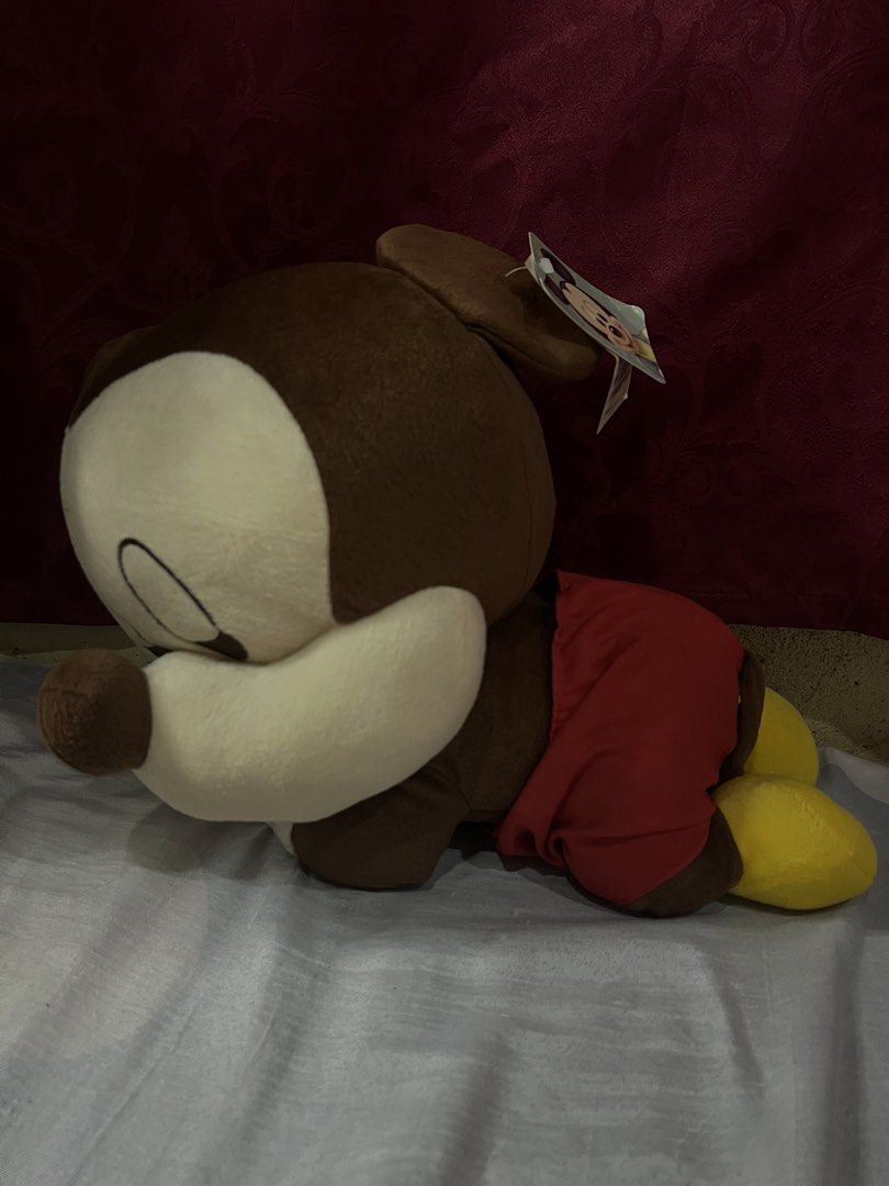 Disney Mickey Mouse lying plush toy with tags (Category: Plushies & Soft Toys) located in Bulacan. Submitted by haven_plushie_dolls.888 (Listing ID 1467959381, Image 2). Description: - Authentic Disney Mickey Mouse lying down plush toy - Super soft brown and tan fabric with iconic red shorts and yellow shoes - Original paper swing tag still attached to the ear - Official Disney tag sewn into the clothing - Perfect for collectors or as a cute gift