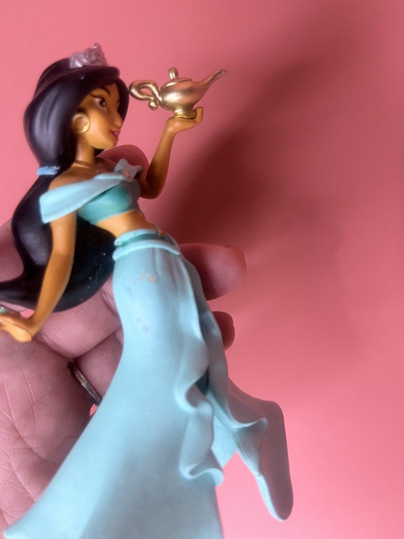 Disney Princess Jasmine Figurine with Magic Lamp (Category: Figurines & Statues) located in Caloocan City. Submitted by snapshop_ph (Listing ID 1468055424, Image 3). Description: - Character: Disney Princess Jasmine holding a gold-colored magic lamp - Appearance: Iconic teal outfit, matching skirt, and tiara in black hair - Authenticity: Official Disney copyright stamp on the underside of the base - Condition: Stands upright on a flat surface; mi