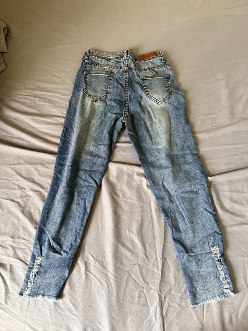 Distressed Hem Denim Skinny Jeans (Category: Jeans) located in Taguig. Submitted by mariiclvra (Listing ID 1467911936, Image 2). Description: - Waistline: 25 - Style: Slim fit with comfortable stretch fabric - Wash: Medium wash blue denim - Details: Ripped distressing at the hems and a small distressed spot near the front pocket - Closure: Standard button and zipper fly - Pockets: Classic five-pocket design with a back leather patch.