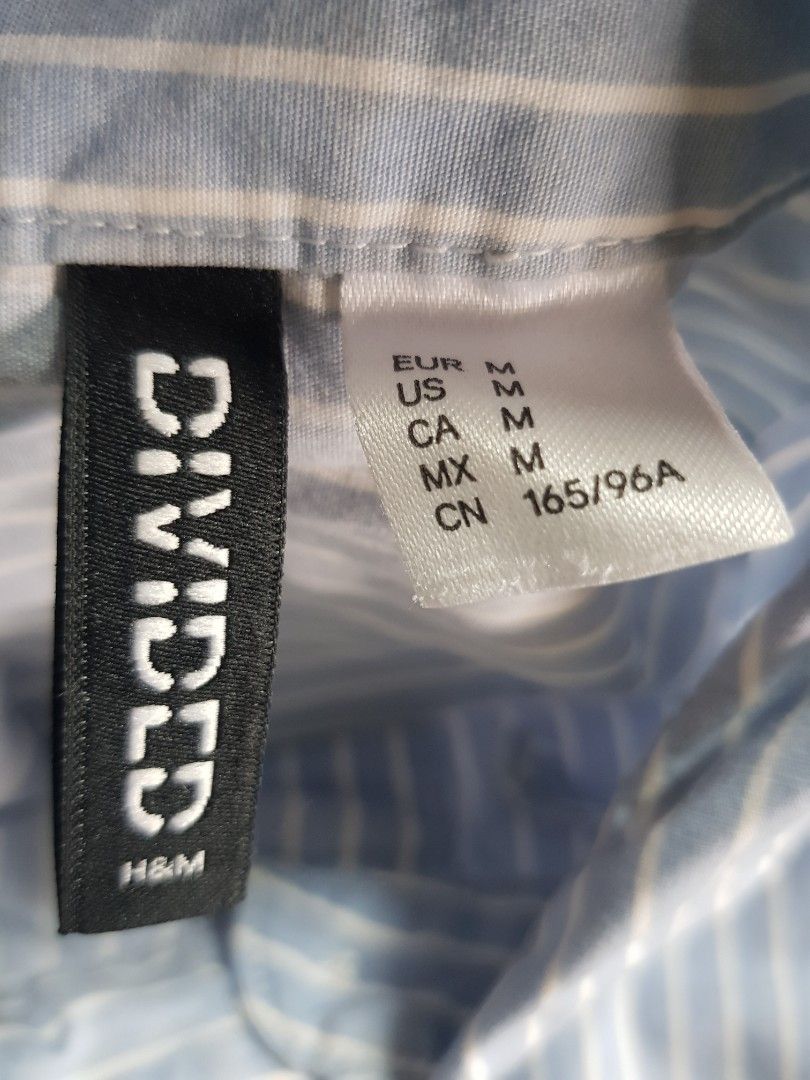 Divided by H&M Blue White Striped Button Down Shirt (Category: Shirts) located in Baguio. Submitted by soonshimcart (Listing ID 1467854714, Image 3). Description: - Brand: H&M - Style: Blue and white striped long-sleeve shirt with button-down front and classic collar - Size: Medium - Features: Single chest pocket, lightweight cotton blend - Condition: Excellent, clean with no stains or tears.