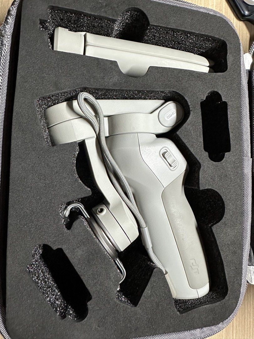DJI Osmo Mobile Gimbal with Tripod and Case (Category: Gimbals & Stabilizers ) located in Cabanatuan. Submitted by s.kit.27 (Listing ID 1468028706, Image 2). Description: - Model: DJI Osmo Mobile Stabilizer - Color: Platinum Grey - Condition: Fully operational, clean grip handle, undamaged body - Inclusions: Magnetic phone clamp, mini tripod stand, USB charging cable, custom-molded carrying case - Care: Well-maintained and stored in its case when