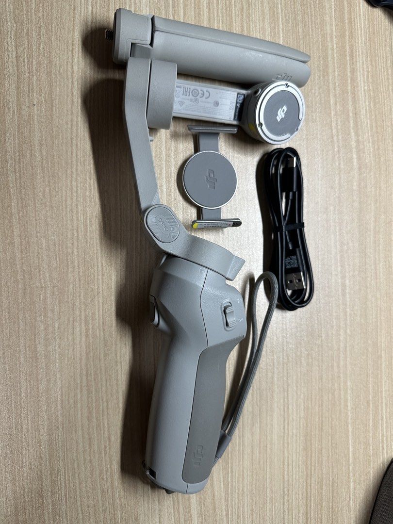 DJI Osmo Mobile Gimbal with Tripod and Case (Category: Gimbals & Stabilizers ) located in Cabanatuan. Submitted by s.kit.27 (Listing ID 1468028706, Image 1). Description: - Model: DJI Osmo Mobile Stabilizer - Color: Platinum Grey - Condition: Fully operational, clean grip handle, undamaged body - Inclusions: Magnetic phone clamp, mini tripod stand, USB charging cable, custom-molded carrying case - Care: Well-maintained and stored in its case when