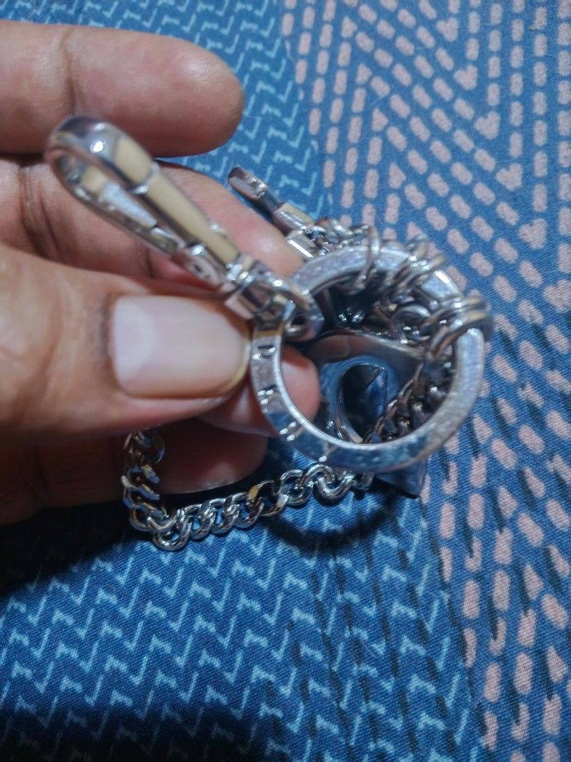 DKNY silver keychain charm with letters (Category: Charms) located in Davao. Submitted by thefrugalshop (Listing ID 1467995704, Image 2). Description: Silver-tone metal keychain from DKNY. Includes hanging block letters spelling out the brand name, a curb chain strap, round split rings, and a clasp hook. Stamped DKNY branding on the clasp and ring. Great accessory for bags, keys, or wallets..