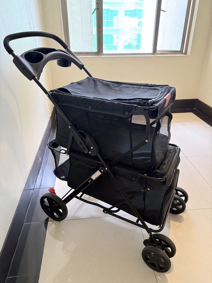 Double Decker Pet Stroller Black (Category: Homes & Other Pet Accessories) located in Quezon City. Submitted by bamsyyyyy (Listing ID 1467887403, Image 2). Description: - Color: Solid Black - Design: Double-decker with two compartments for multiple small dogs or cats - Comfort & Safety: Breathable mesh windows and secure zipper closures - Convenience: Handlebar with built-in cup holder tray and under-seat storage basket - Mobility: Foldable metal