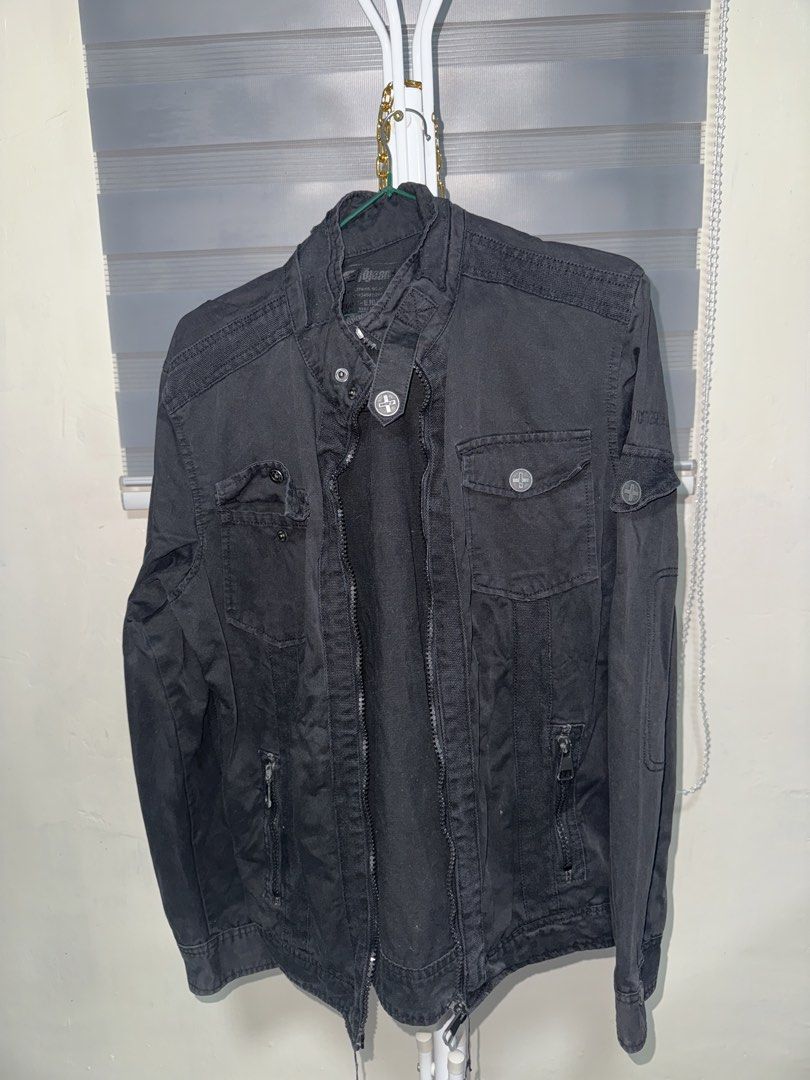 Egojeans Black Utility Jacket Military Style (Category: Coats, Jackets and Outerwear) located in La Trinidad. Submitted by prelovedandfindsbyji (Listing ID 1467930899, Image 1). Description: - Brand: Egojeans - Color: Black - Material: Sturdy cotton fabric - Design: Stand collar with button strap, full front zip - Pockets: Multiple chest pockets with cross logo hardware and zippered lower pockets - Size: Tag size 50 / F185PLUS - Style: Perfect la